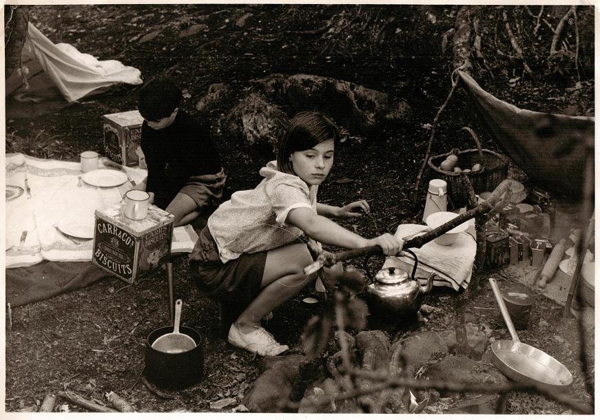 Susan taking the kettle off the fire on Peel Island, Coniston Water